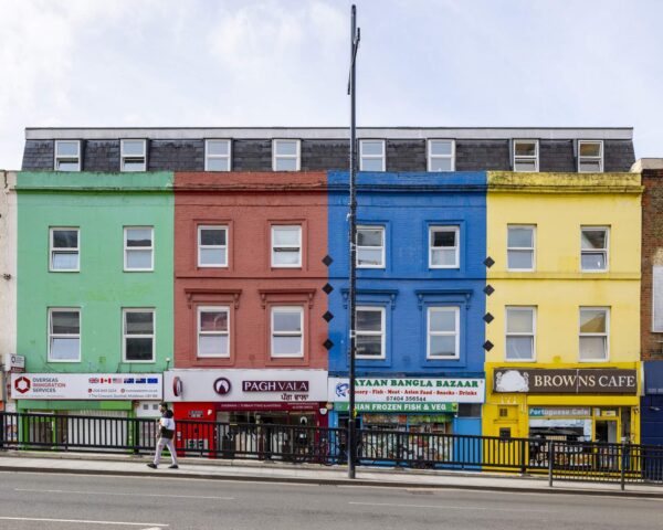 A row of colourful brick buildings with shops